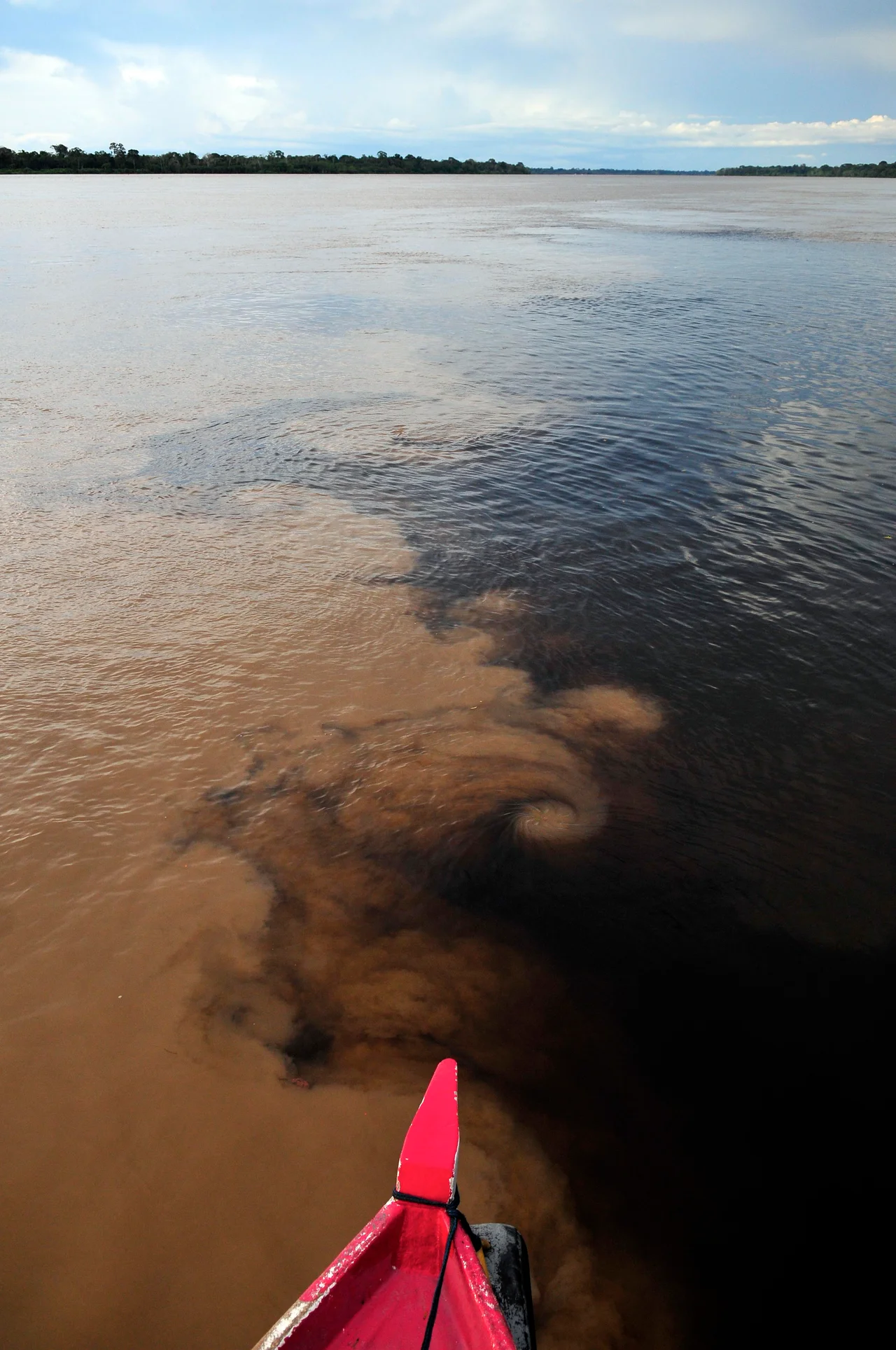 The confluence of the Madeira River (brown) and Aripuanã River (dark) in the Brazilian Amazon, near Novo Aripuanã.