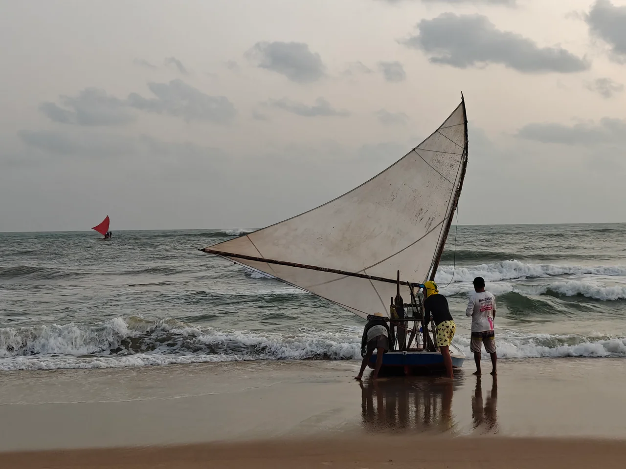 Three fishermen are ready to push their traditional jangada into the waves to go on a fishing expedition at sunrise. Another one has just left.