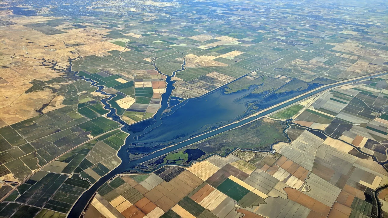 Aerial view of the Sacramento River Deep Water Ship Canal and some adjoining and nearby sloughs and farm country. Dixon and Davis are visible in the distance.