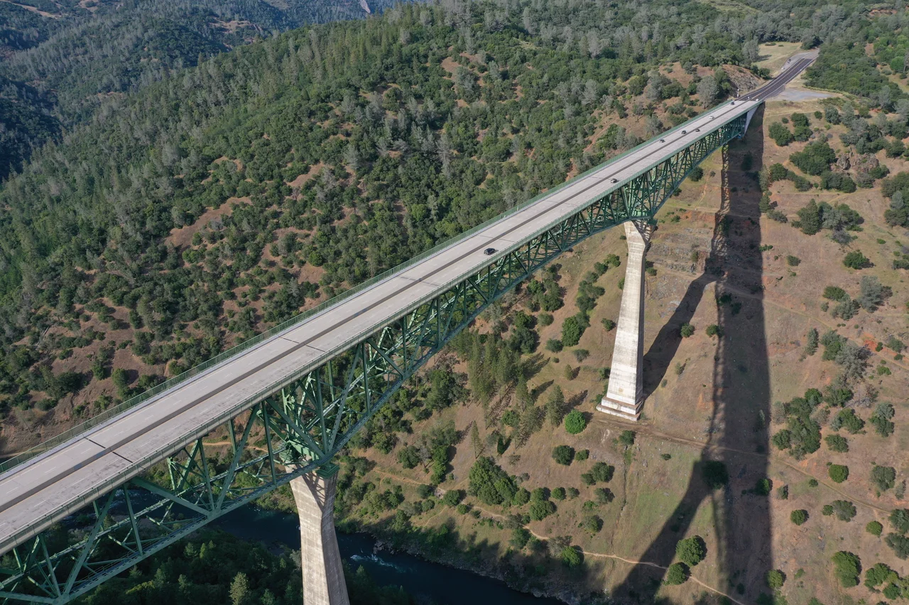 A digital photo of the southern face of the Auburn-Foresthill Bridge (also known as the Foresthill Bridge) taken from the confluence of the North and Middle Forks of the American River located within the Auburn State Recreation Area (near Auburn, California) on April 27, 2008 at 10:23:58 AM Pacific Daylight Time.