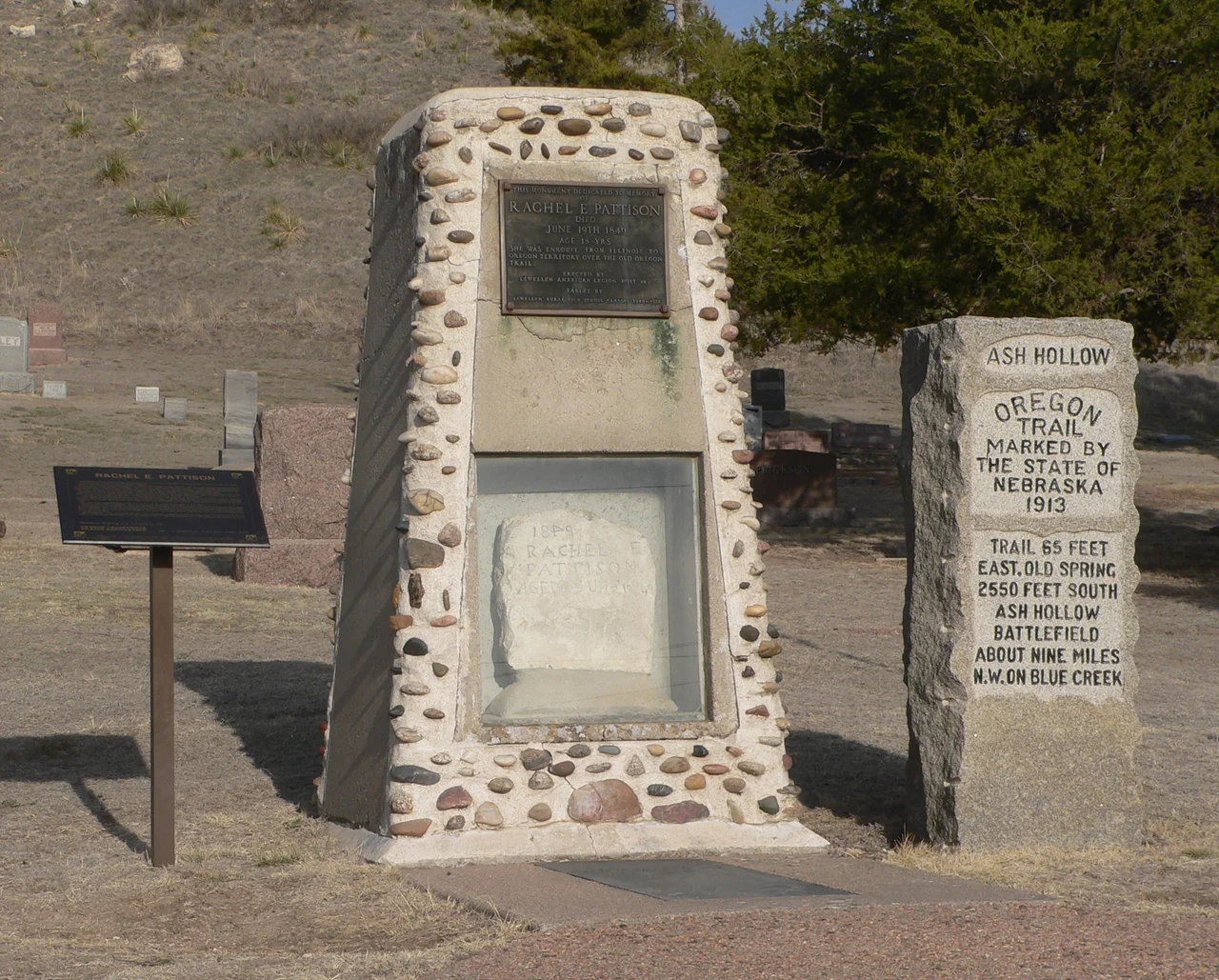 Monuments in Ash Hollow Cemeter, located on U.S. Highway 26 southeast of Lewellen, Nebraska. In the center is a large monument containing the Rachel Pattison marker; at left is a small interpretive sign concerning Pattison; at right is a 1913 Oregon Trail monument.