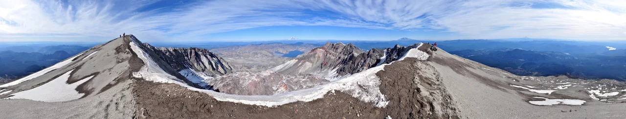 360° panorama from the summit of Mount St. Helens as seen on an early-October afternoon. In the foreground is the ice-covered crater rim. Visible in the lower center is the lava dome. Steam rises from several dome vents. Above the dome, in the upper center, lie Mount Rainier and Spirit Lake. Mount Adams appears to the right of Rainier on the horizon as well as Mount Hood and Mount Jefferson on the far right. Also on the far right are glimpses of the Swift Reservoir, Yale Lake, Lake Merwin and the Lewis River. Climbers stand on the crater rim and are visible along the Monitor Ridge climbing route. Photo by Gregg M. Erickson