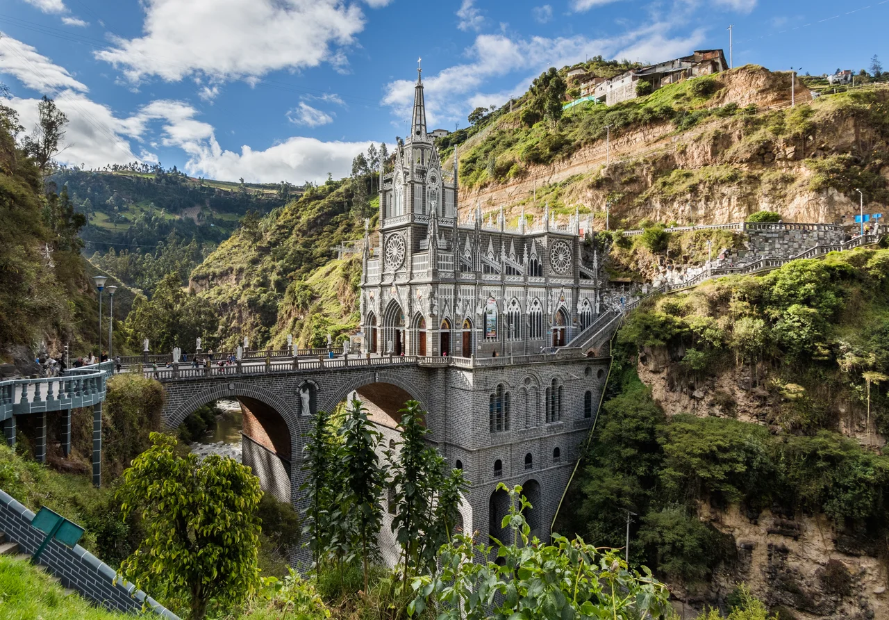Las Lajas Sanctuary is a basilica church located in the southern Department of Nariño, municipality of Ipiales, Colombia. The place is a popular pilgrimage location since the apparition of the Virgin Mary in 1754. The first shrine was built by 1750 and was replaced by a bigger one in 1802 including a bridge over the canyon of the Guáitara River. The present temple, of Gothic Revival style, was built between 1916 and 1949.