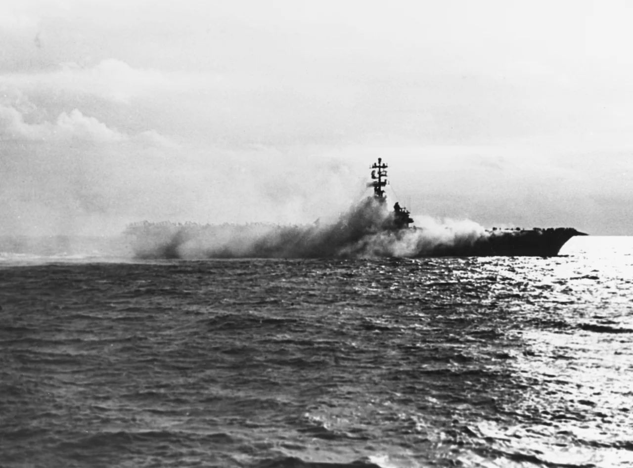 The U.S. Navy aircraft carrier USS Oriskany (CVA-34) on fire, 26 October 1966. Smoke pours from Oriskany's Hangar Bay No.1, during the fire which killed 44 of her officers and men.