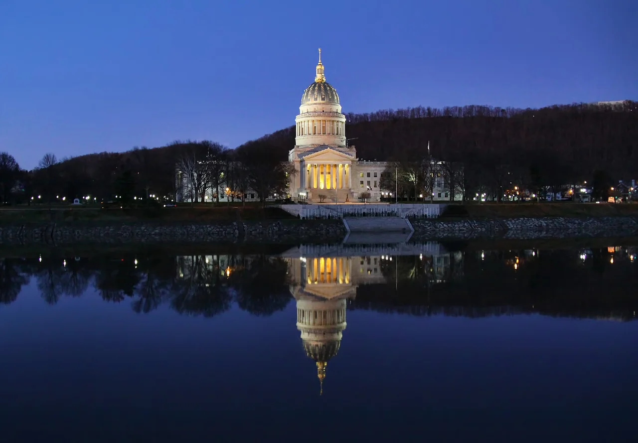 As I was traveling through Charleston, the capital of West Virgina, during blue hour (my favorite time of day) a couple of days after Thanksgiving, I happened upon this beautiful sight of the State Capitol Building reflected in the Kanawha river flowing by in total stillness, so I just had to stop and capture the scene. I didn't have a tripod handy, so this is not a long-exposure nightshot, just a regular hand-held shot accomplished by bumping up the ISO as much as I dared to get correct exposure at acceptable shutter speed (ended up being 1/40 sec) and doing my best to keep the camera steady.
