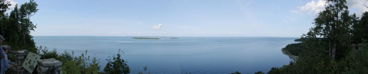 A stitched panorama taken from Sven's Bluff in Peninsula State Park, Wisconsin. The four Strawberry Islands are visible in the foreground, with the much larger Chambers Island visible in the distance.