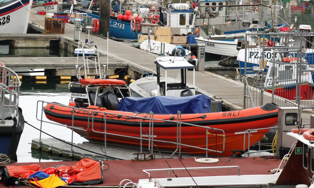 Penlee Lifeboat Station's inshore lifeboat B-893 Mollie and Ivor Dent in its floating Versadock amoungst the fishing boats at Newlyn.