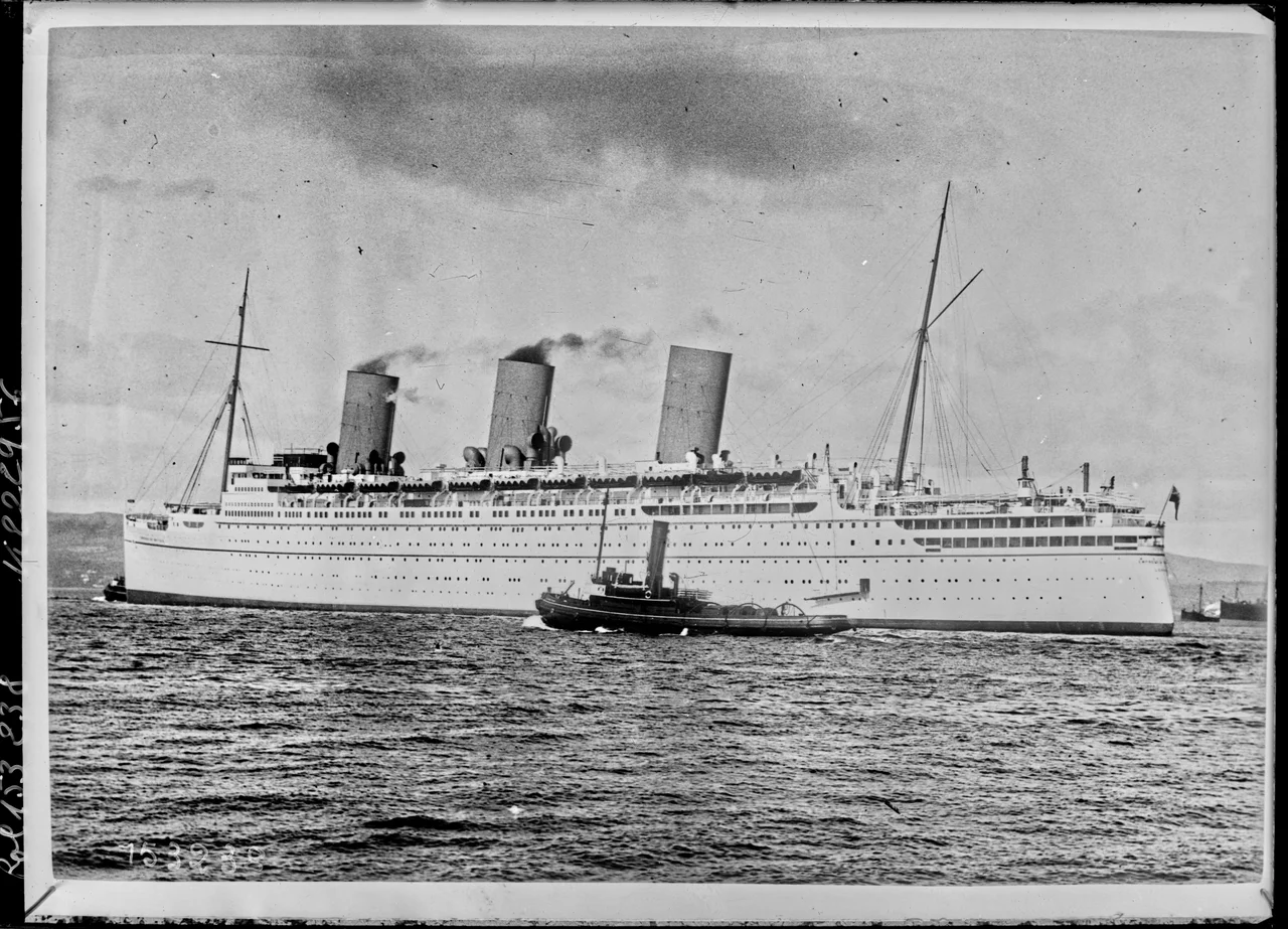 RMS Empress of Britain arriving at Greenock with Canadian troops aboard. (HMS Hood is visible in the background.)