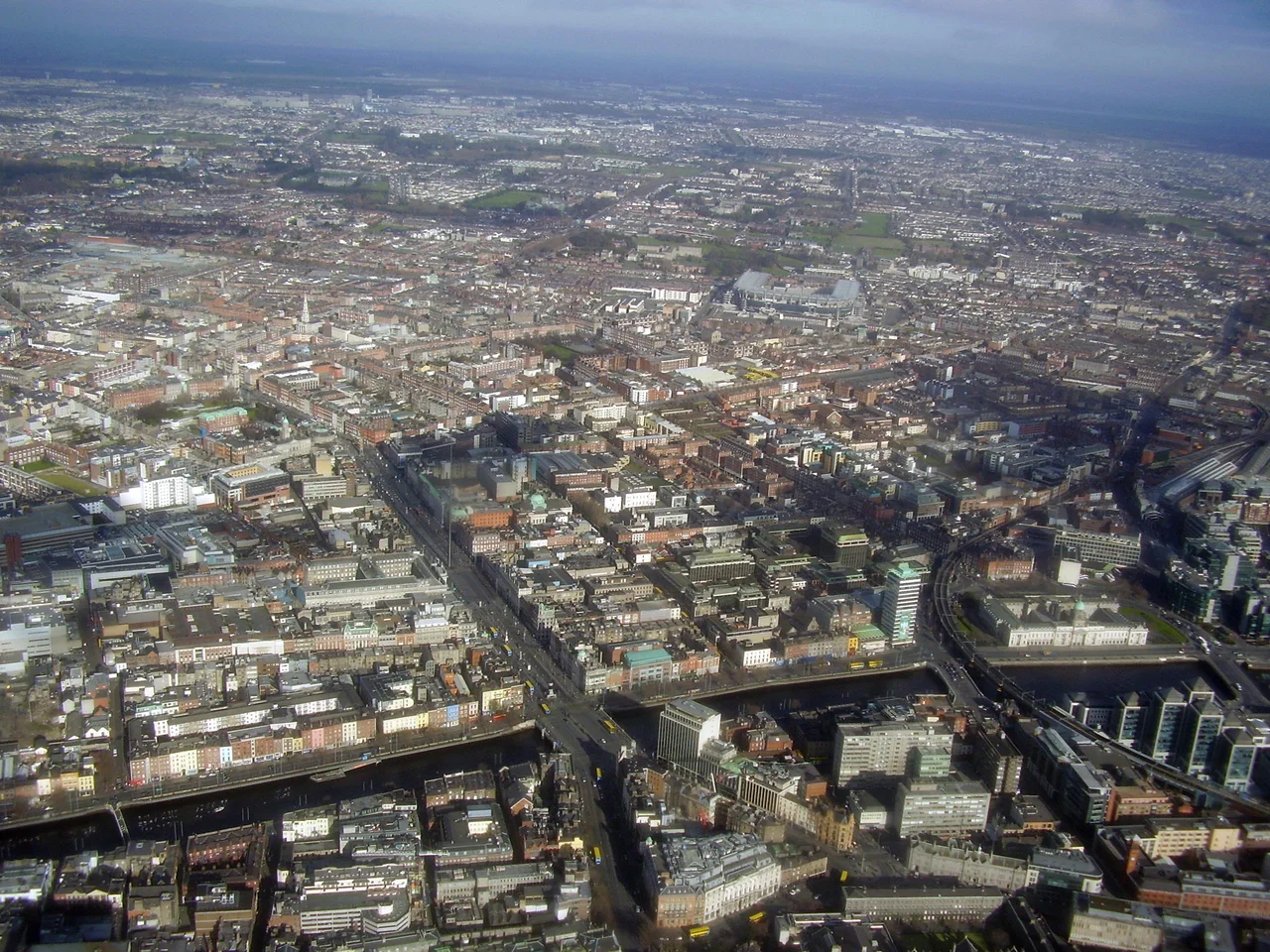Aerial view of northeastern Dublin City in Ireland. The River Liffey (left-to-right at the bottom of the picture) divides the north part of the city from the south.