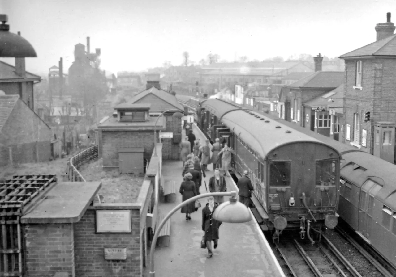 Epping Station, with Ongar auto-train and LT Central Line train.
View SW, towards Loughton, Stratford and London on the ex-GER suburban line from Liverpool Street, continuing on to Ongar. From 26/9/49 LPTB Central Line terminated here, from Ealing Broadway/West Ruislip. The service on to Ongar then continued as a steam shuttle until 11/57, when it was electrified, but ceased on 30/9/94.