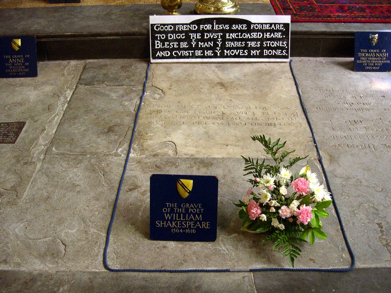 William Shakespeare's grave, Holy Trinity Church, Stratford-on-Avon, England
On his grave is written:
Good frend for İesus sake forbeare,
To digg the dvst encloased heare.
Bleste be þe man þt spares thes stones,
And cvrst be he þt moves my bones.


In modern English:
Good friend for Jesus sake forbear,
To dig the dust enclosed here.
Blessed be the man that spares these stones,
And cursed be he that moves my bones.