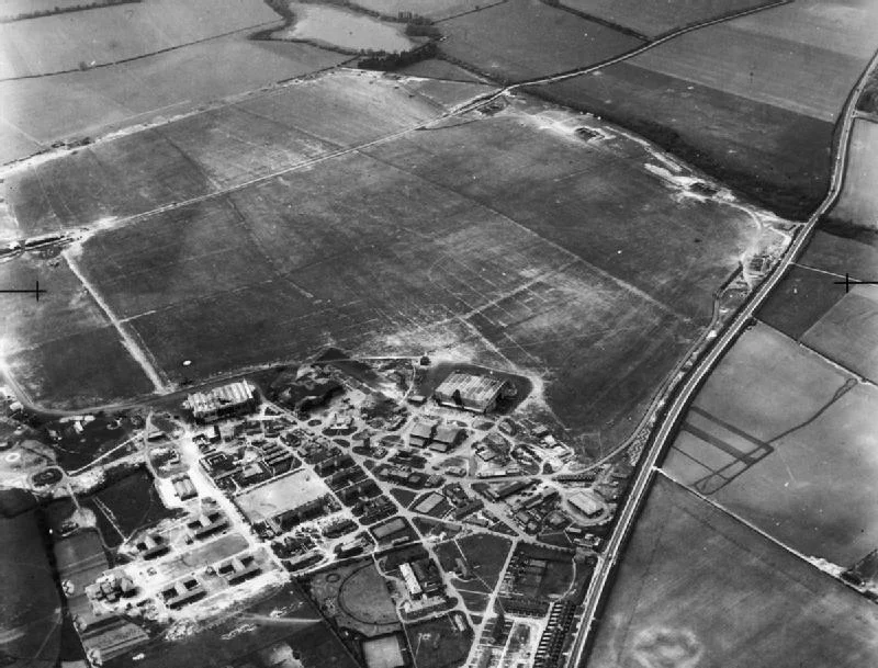 IWM caption: Oblique aerial view of RAF Wittering, Cambridgeshire, showing the technical and domestic sites and airfield looking west from a point over the A1.  White Water Lake can be seen at top centre.