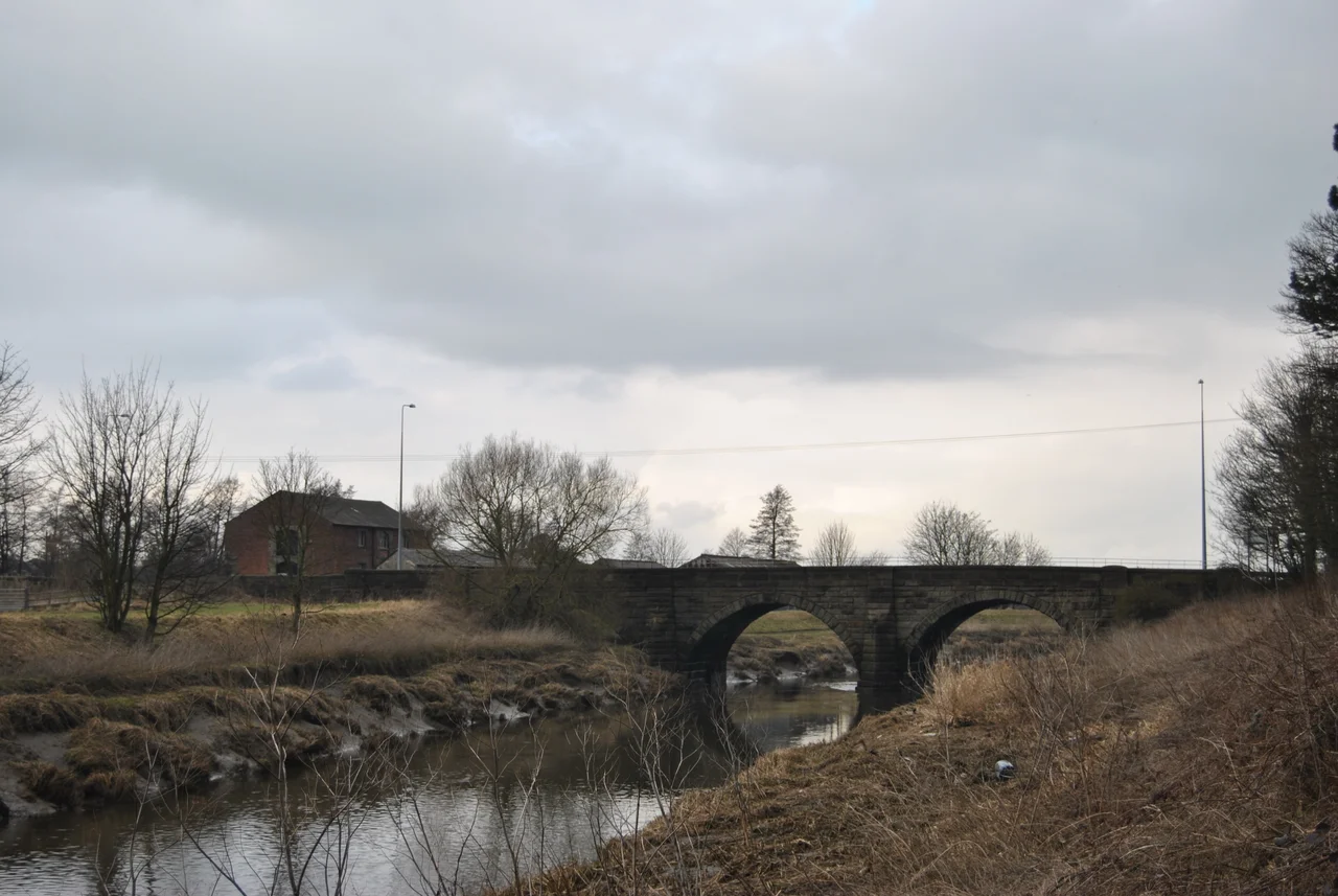 A view of Bank Bridge and the warehouse from the banks of the River Douglas.