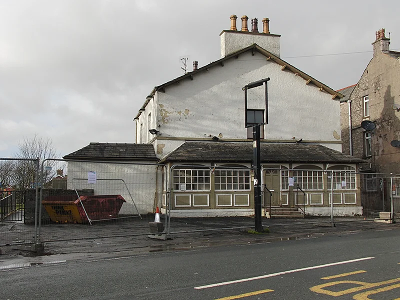 A front-on view of the Royal Hotel, Silverdale, showing the run-down state of the building and the fencing and skip brought in since the pub was closed.