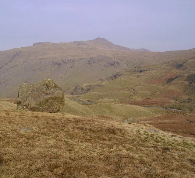 Wrynose Pass The famous Three Shires Stone just visible on the road. Picture taken from 'Lancashire'.