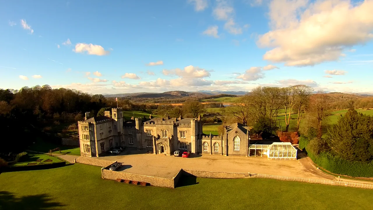 The front elevation of Leighton Hall, with the distant fells of The Lake District visible on the horizon behind.
