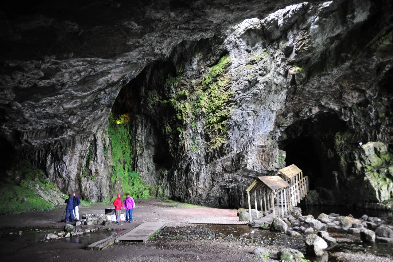 Outer chamber of Smoo Cave, Scotland. The main entrance is to the right; the covered walkway leads to the second (inner) chamber with the waterfall.