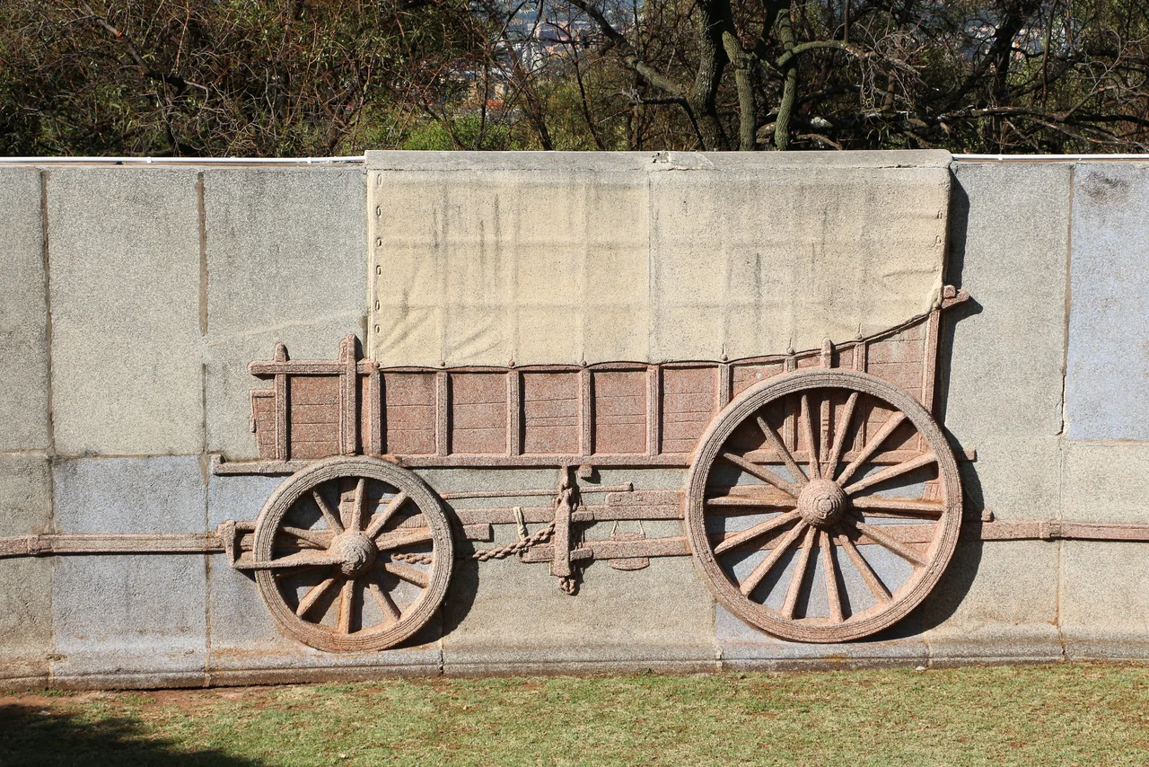 The Voortrekker Monument outside Pretoria was completed in 1949. Inside is a marble frieze containing 27 panels commemorating events of the Great Trek in which farmers of mainly Dutch origin emigrated from the eastern frontier region of the Cape Colony, to the inland regions of the current South Africa, between 1835 and 1854. At the centre of the monument is the cenotaph which bears the inscription "We for thee, South Africa". An opening in the dome atop the monument is positioned so that every year at noon on the 16th of December a beam of sunlight illuminates the cenotaph. Prior to the 1994 elections which heralded a new dispensation, December 16th was celebrated as the "Day of the Vow", commemorating the victory over Zulus forces in the Battle of Blood River; it remains a holiday but is now called "Reconciliation Day". Surrounding the monument is a circular wall with reliefs representing 64 wagons pulled into a circle.
