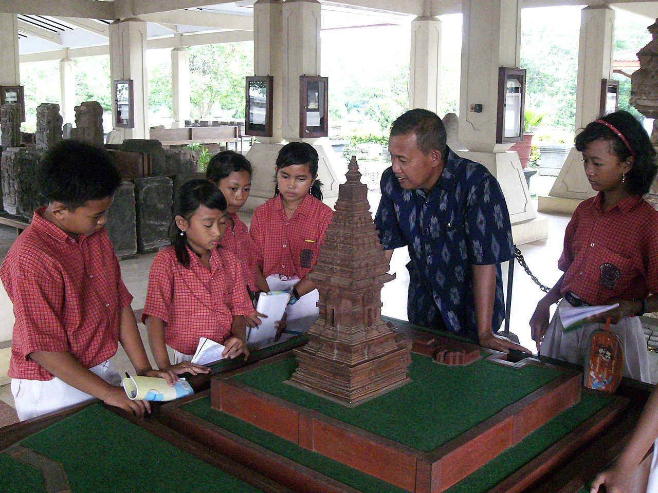 The students listen the explanation and examine the model of Candi Jawi during their study tour at Trowulan Museum, East Java, Indonesia.