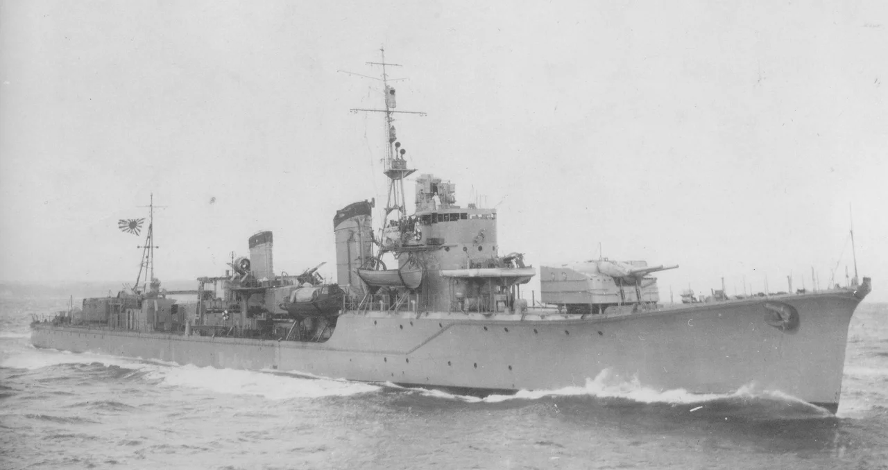 The Japanese destroyer Harusame, photographed through the periscope ot the U.S. Navy submarine USS Wahoo (SS-238) after she had been torpedoed by the submarine near Wewak, New Guinea, on 24 January 1943. Harusame's back is clearly broken, but she was repaired and returned to service despite this heavy damage.

Wartime intelligence evaluated this photo as showing one of the Asashio-class (see Photographic Intelligence Report # 82, 17 March 1943). However, the ship's bridge structure identifies her as a Shiratsuyu-class destroyer, with the # 2 (single) 5 gun mount removed.
