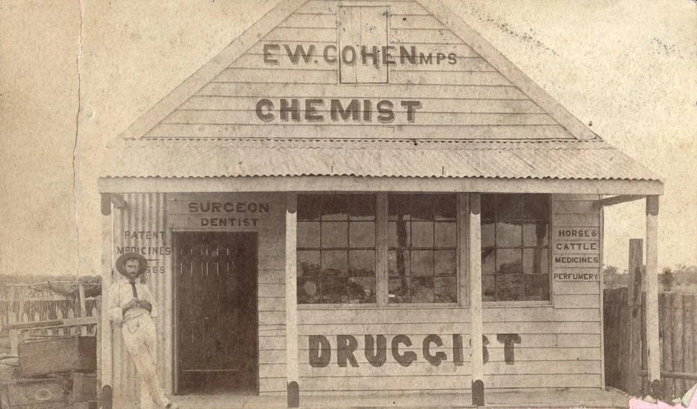 Chemist building in Arrilalah, Longreach district, 1884
Chemist and druggist, E. W. Cohen. Signs on the front of the shop advertise surgeon, dentist, druggist, patent medicines, horses and cattle medicines and a perfumery.