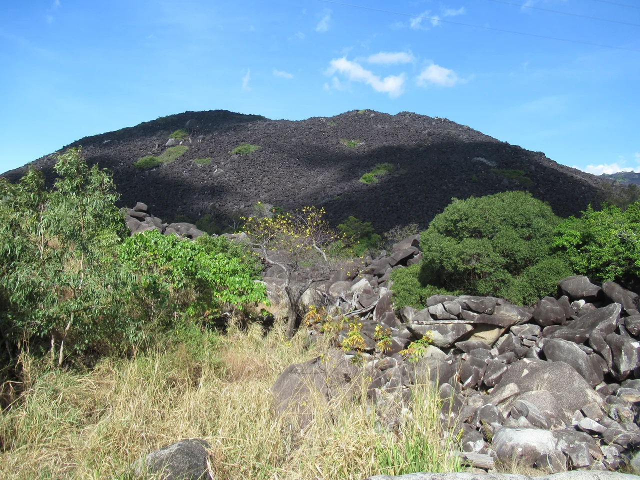 Black Mountain in Black Mountain (Kalkajaka) National Park near Cooktown, Queensland, Australia. The mountain's grey granite boulders are blackened by a film of microscopic blue-green algae growing on the exposed surfaces.