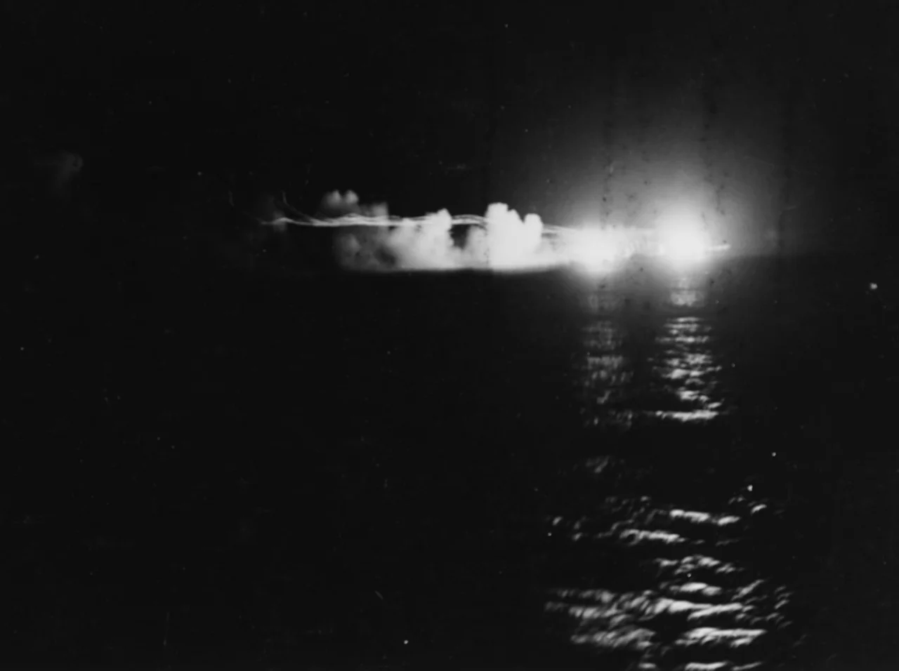 The light cruisers USS St. Louis (CL-49) and HMNZS Leander (75) firing during the Battle of Kolombangara, 13 July 1943. This is probably the battle's initial engagement, in which the Japanese light cruiser Jintsu was sunk by gunfire and torpedo hits and Leander was heavily damaged by a Japanese torpedo.
