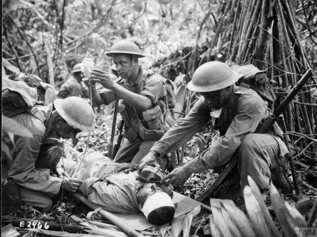 A Fijian medical orderly administers an emergency plasma transfusion during heavy fighting on Bougainville.