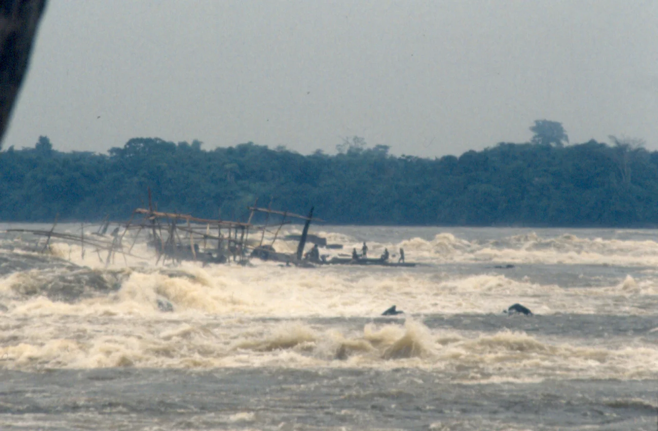 The Boyoma Falls rapids/cataracts of the Lualaba River —  near Kisangani, in the Democratic Republic of the Congo.
The Wagenya peoples are indigenous fishermen who have developed a unique technique to fish in the river. They build a huge system of wooden tripods across the river. These tripods are anchored on the holes naturally carved in the rock by the water current. To these tripods are anchored large baskets, which are lowered in the rapids to “sieve” the waters for fish. It is a very selective fishing method, as these baskets are quite big and only large fish are entrapped.