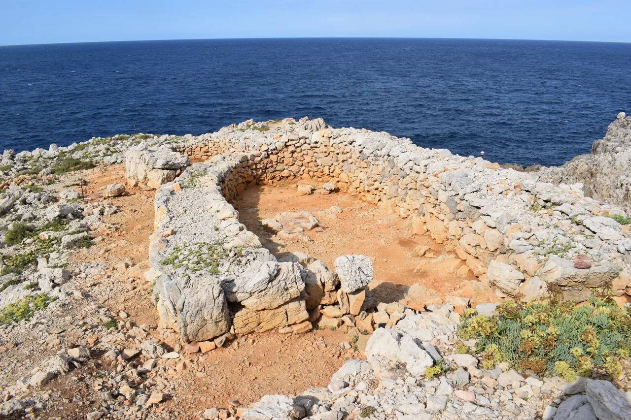 Reste eines naviformen Hauses in der Küstensiedlung von Cala Morell.
