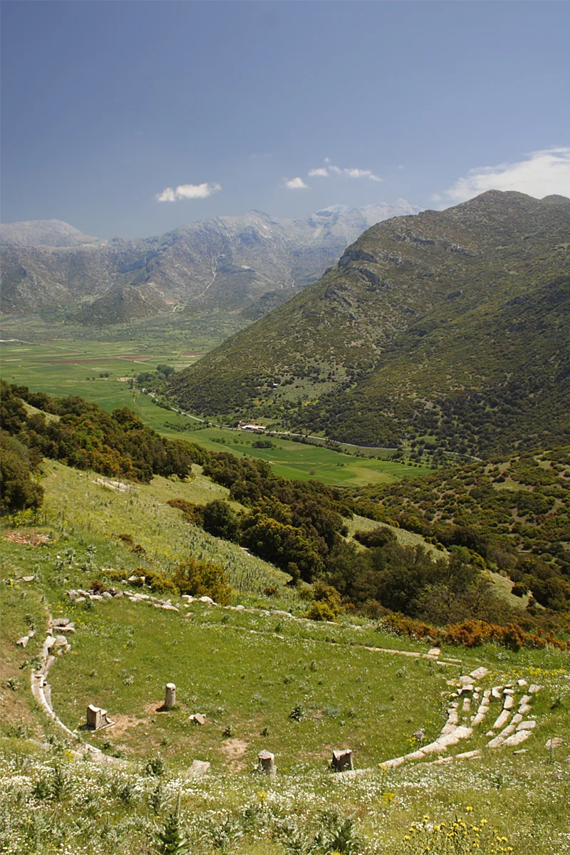 Orchomenus is an ancient Greek town, Arcadia, Peloponnese. In the back: A closed karst depression. Of its 7,7 km roughly 2,4 km are visible in this photo. In the still existing book “Description of Greece”, Pausanias (ca. AD 110 – 180) describes Arcadia and Orchomenus, its theatre (photo) and a plain, which is covered by a lake. Today farmers complain, that fields remain wet or even flooded for too long, in spite of drainage: katavothres (Greek term for ponors) and one artificial tunnel do not drain fast enough.