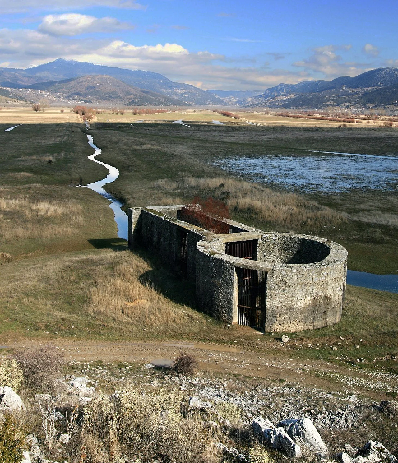 One of 3 Ponors in the southern part of the polje Feneos, Corinthia, Peloponnese.
When precipitation  of winters is exceptionally rich, parts of the polje become flooded even nowadays; until the second half of the 19th century there was even an almost permanent lake. Marks of the watertable at the bottom of the slopes are still visible. Construction of a system of draining ditches reduced floods.

By hydrogeological tracertests in 1984 subsurface drainage through the surrounding limestone mountains emerged in a karst spring of river Ladonas, 15 km south east.