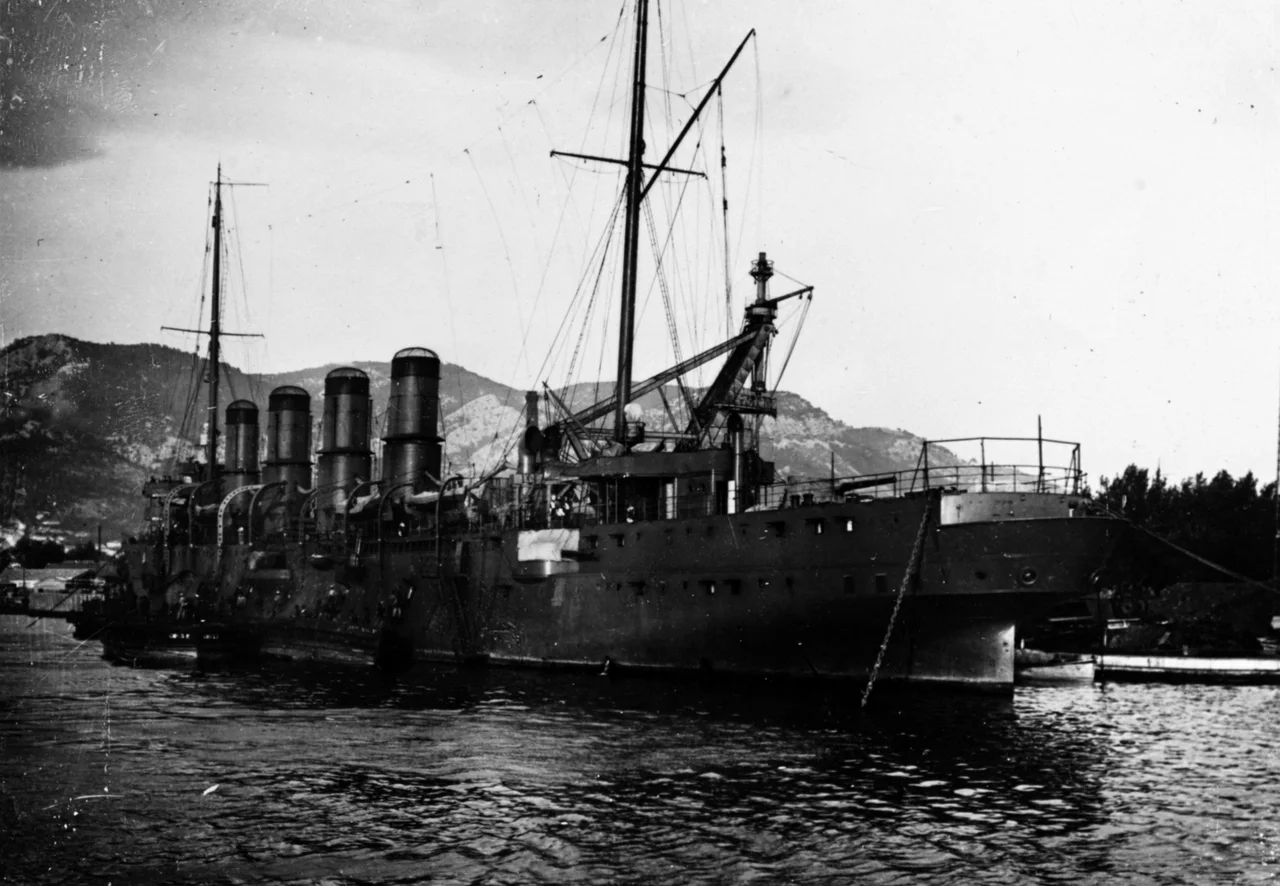 The French cruiser French cruiser Châteaurenault 1898 2 photographed at Toulon, France, during World War I. The ship apparently is taking coal aboard from lighters to port. A large dockyard crane appears just behind the cruiser amidships.