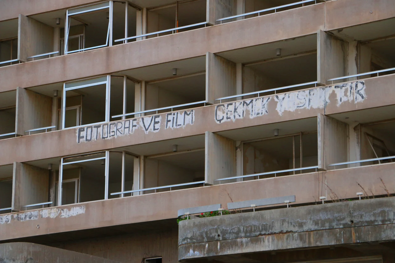 Part of a hotel front in the Varosha Ghost Town, Famagusta CYPRUS.
The tourist resort town was abandoned in 1974 after the Turkish Army captured most of Famagusta. This area was fenced off and never officially inhabited after the war, unlike the rest of Northern Cyprus.
Painted on the exterior is a warning that "taking pictures or filming this is prohibited", written in Turkish.
