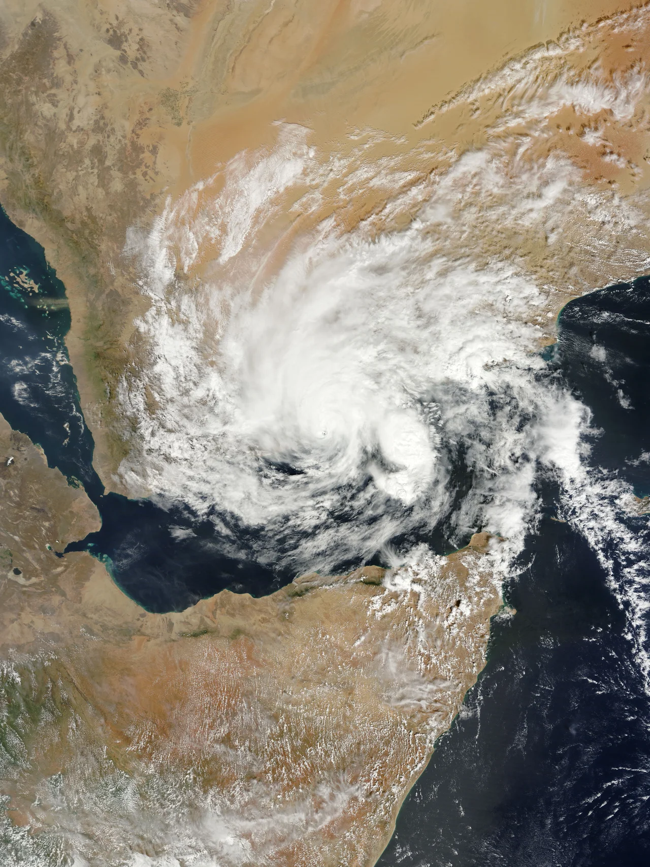 Before the year 2004, only two tropical cyclones had ever been noted in the South Atlantic Basin, and no hurricane. However, a circulation center well off the coast of southern Brazil developed tropical cyclone characteristics and continued to intensify as it moved westward. The system developed an eye and apparently reached hurricane strength on Friday, March 26, before eventually making landfall late on Saturday, March 27, 2004.
The crew of the International Space Station was notified of the cyclone and acquired excellent photographs of the storm just as it made landfall on the southern Brazilian state of Santa Catarina (the storm has been unofficially dubbed “Cyclone Catarina”). Note the clockwise circulation of Southern Hemisphere cyclones, the well-defined banding features, and the eyewall of at least a Category 1 system. The coastline is visible under the clouds in the upper left corner of the image.
