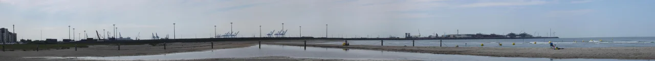 View on the eastern dam of the Port of Zeebrugge, Brugge, seen from the beach of Heist, Knokke-Heist, West-Flanders, Belgium.