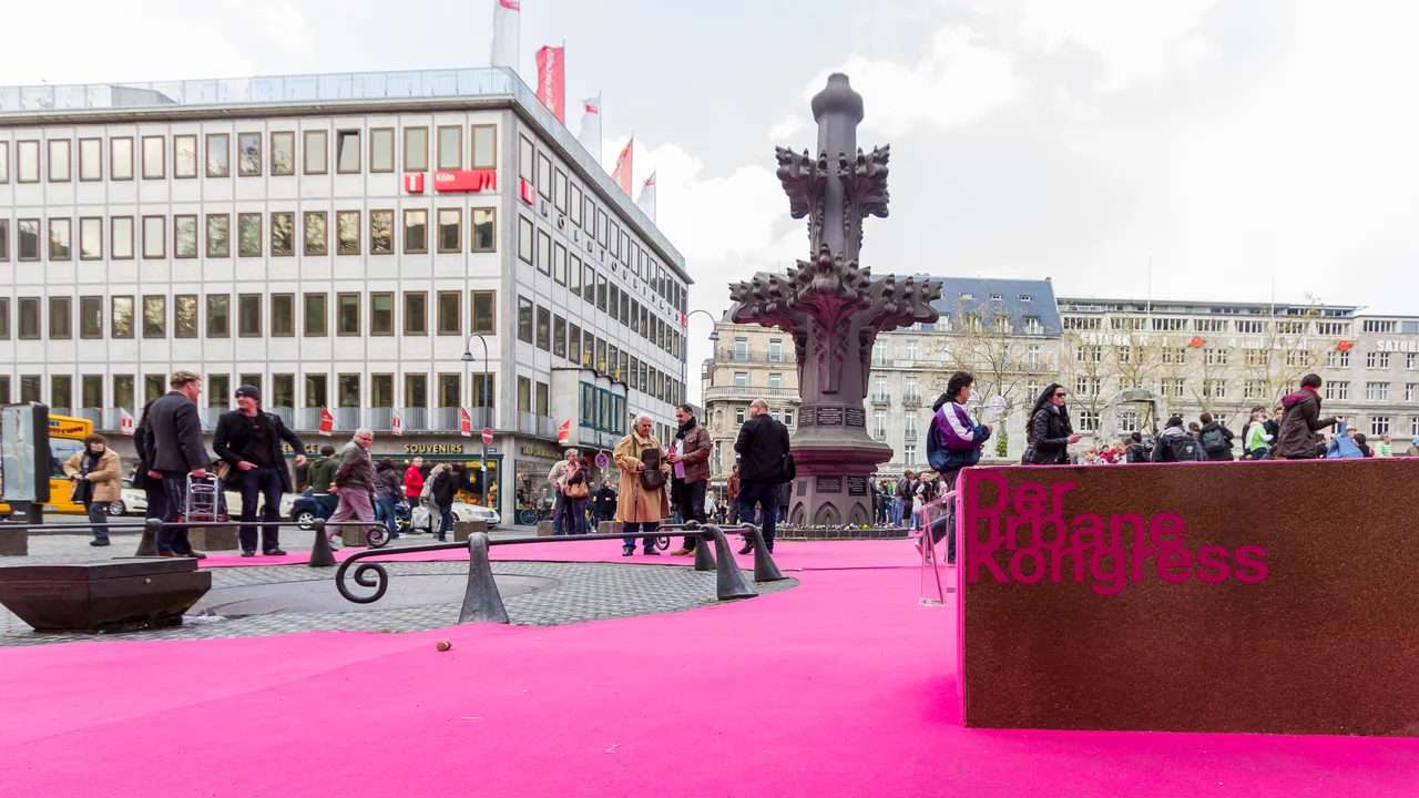Der urbane Kongress - Taubenbrunnen und Kreuzblumenreplik. Der Kardinal-Höffner-Platz Köln wurde für den urbanen Kongress mit einem pinken Teppich ausgelegt