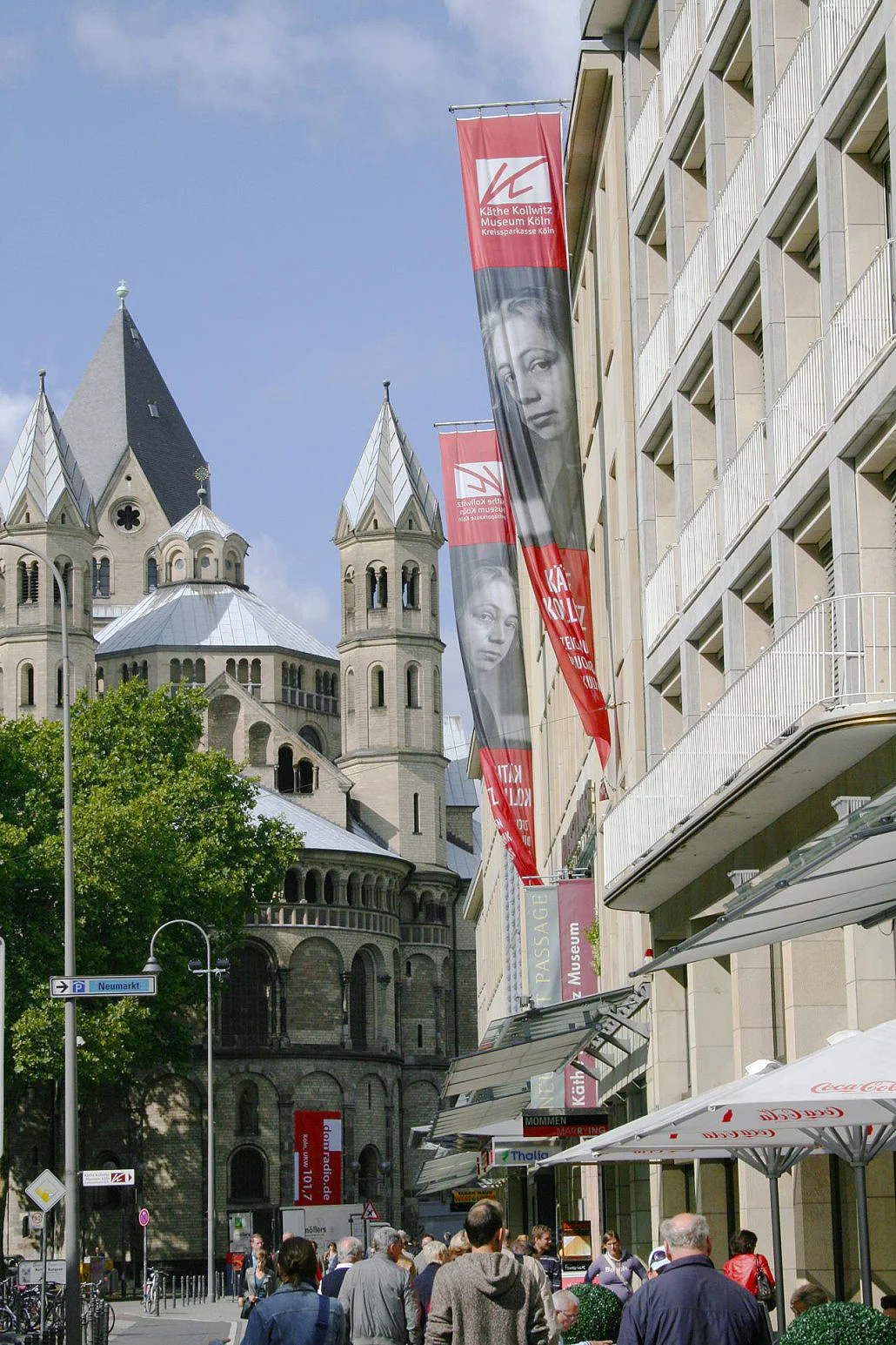Fassade des Käthe Kollwitz Museum Köln mit Fahnen. Blick in Richtung St. Aposteln.