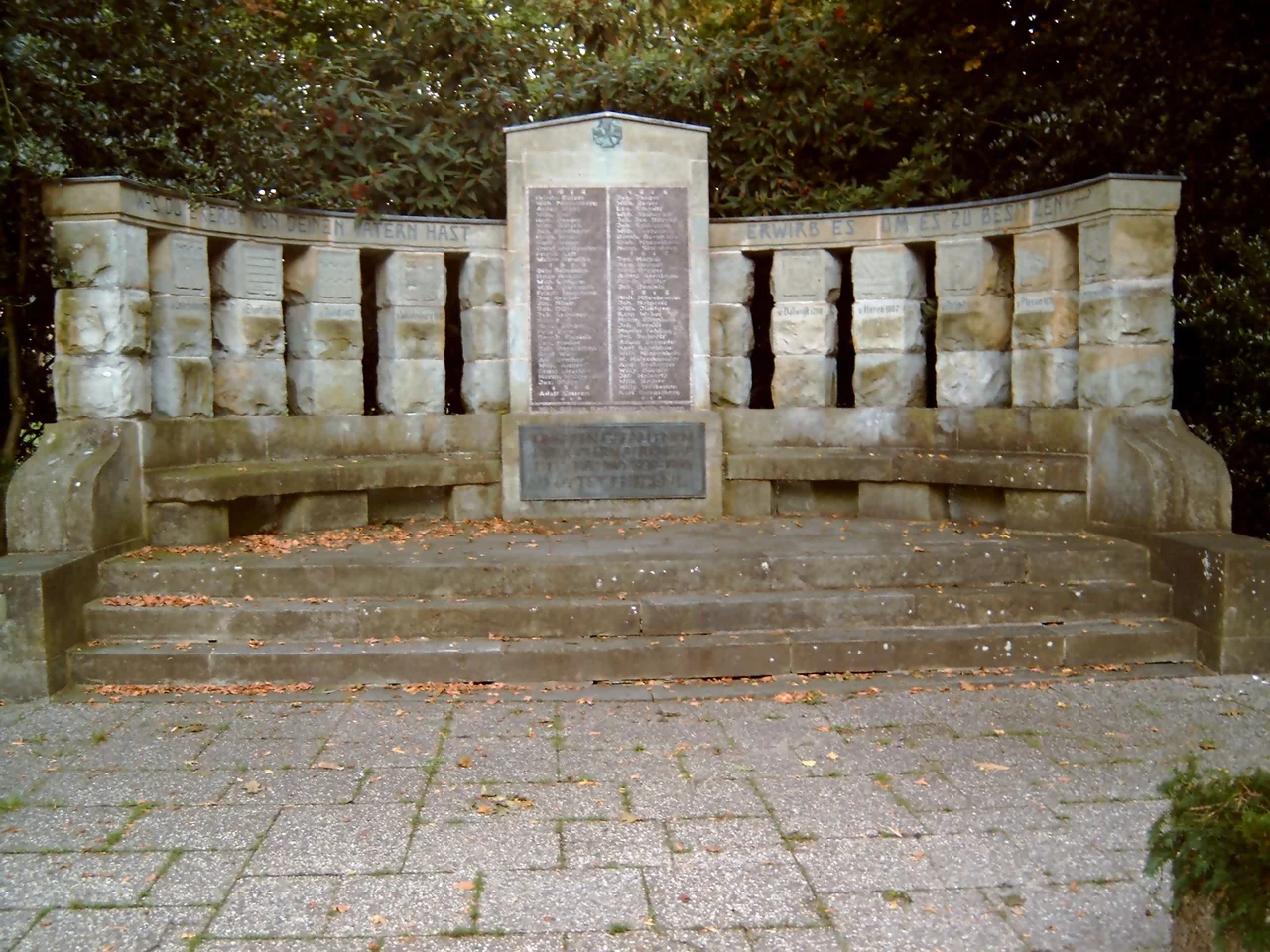 Unterbacher Denkmal vor dem Friedhof in Düsseldorf-Unterbach. Auf der Tafel in der Mitte werden die Namen der Gefallenen des 1. Weltkriegs genannt. Wappen und Namen der Herren von Haus Unterbach sind in die Pfeiler gemeißelt. 1913 eingeweiht war dies das Kaiser-Jubiläumsdenkmal. Damals auf der mittigen Tafel das Konterfei des Kaisers. Werk des Düsseldorfer Bildhauers Joseph Hammerschmidt.