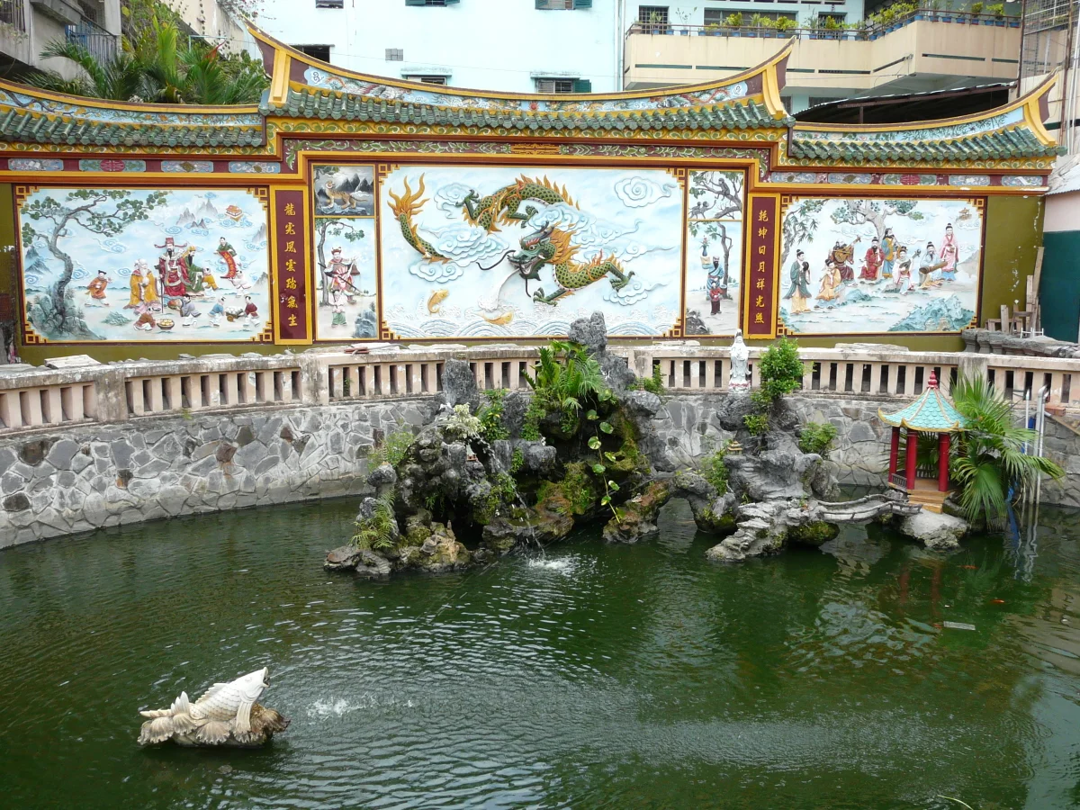 This photograph shows the garden across from Quan Am Pagoda in Cho Lon, Ho Chi Minh City, Vietnam. The motifs on the panels are Taoist.