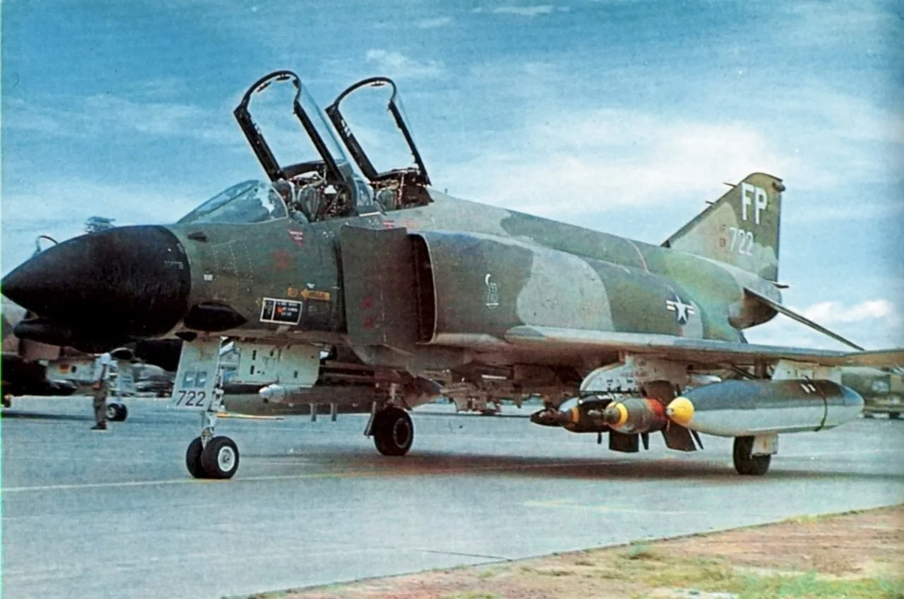 A U.S. Air Force McDonnell F-4D Phantom II from the 497th Tactical Fighter Squadron, 8th Tactical Fighter Wing, taxies at Ubon Royal Thai Air Force base in 1971. The aircraft is armed with two BOLT-117 (BOmb, Laser Terminal-117). The BOLT-117 was later redesignated as the GBU-1/B (Guided Bomb Unit) and was the world's first laser guided bomb. The aircraft and carries a AN/ALQ-72 jamming pod under the wings, and a strike camera in the forward left missile bay.