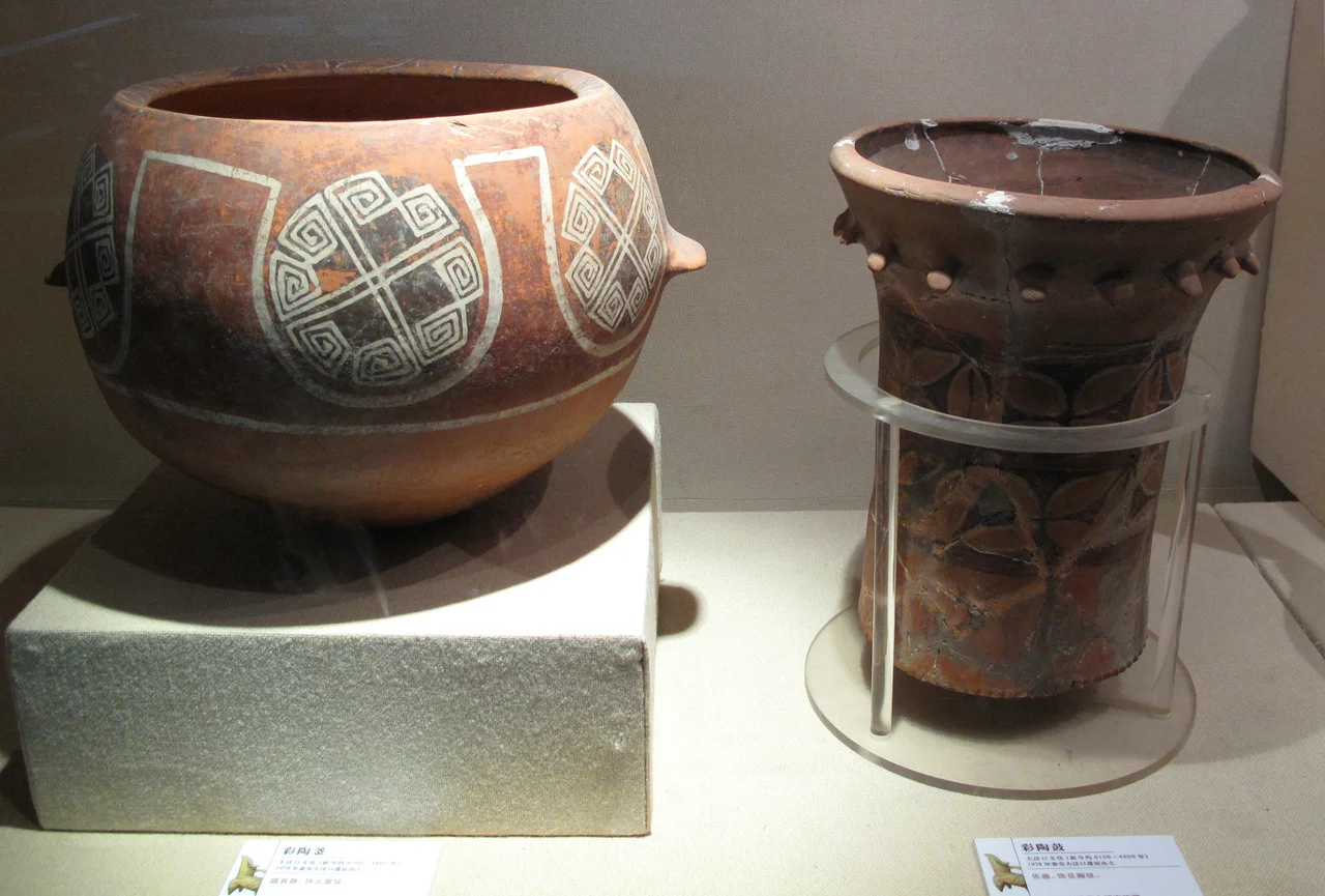 Neolthic Pottery. Dawenkou Culture, 4th millennium BC.
Shandong Provincial Museum, Jinan
A deep bowl and a drum are shown here. The main pattern on the bowl is formed by eight squared spirals that are connected by crossing diagonal arms. The drum is missing its drumhead, which could have been stretched taut over the top and attached at the lugs.